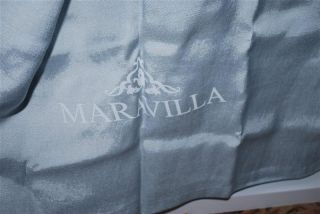 Verdeckt durch blaugraue Vorhänge mit dem Schriftzug Maravilla